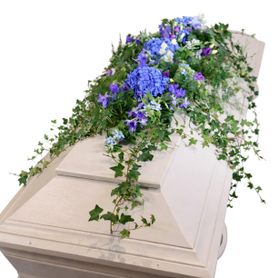 Kista dekorerad med blommor i blå och lila nyanser samt gröna rankor.